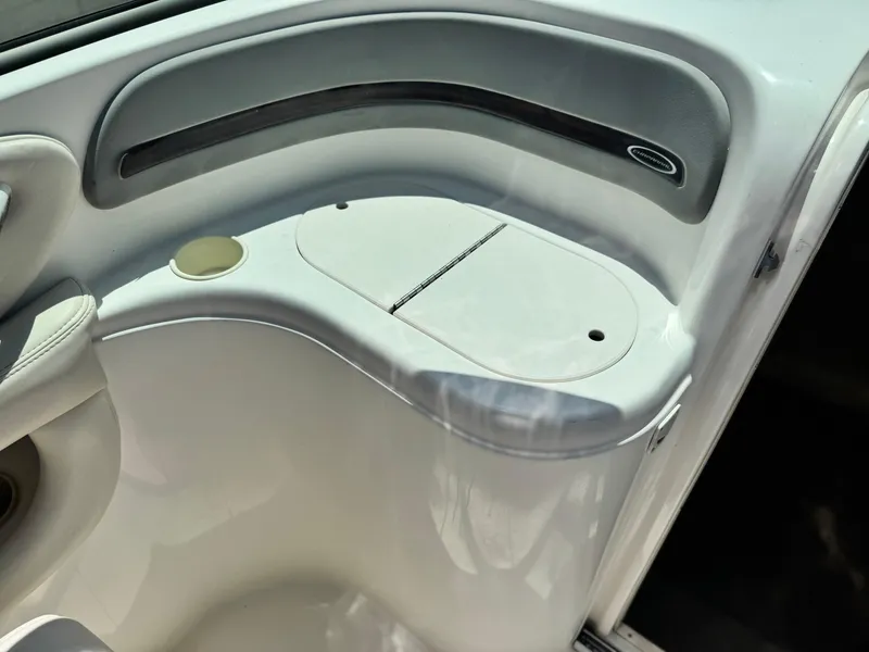 Slide: The Image of 2004 Chaparral 265 SSi boat interior detail with storage compartment and cup holder. - 13