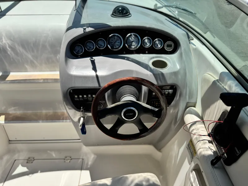 Slide: The Image of 2004 Chaparral 265 SSi boat dashboard with gauges and wooden steering wheel. - 17