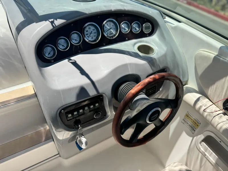Slide: The Image of Dashboard of a 2004 Chaparral 265 SSi boat with gauges and wooden steering wheel. - 18