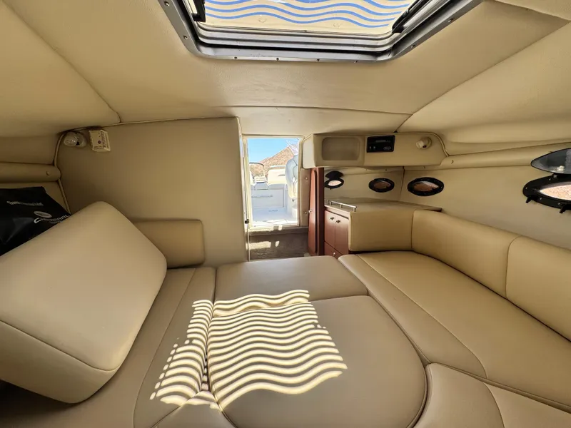 Slide: The Image of Interior of 2004 Chaparral 265 SSi boat cabin with beige seating and overhead hatch. - 20