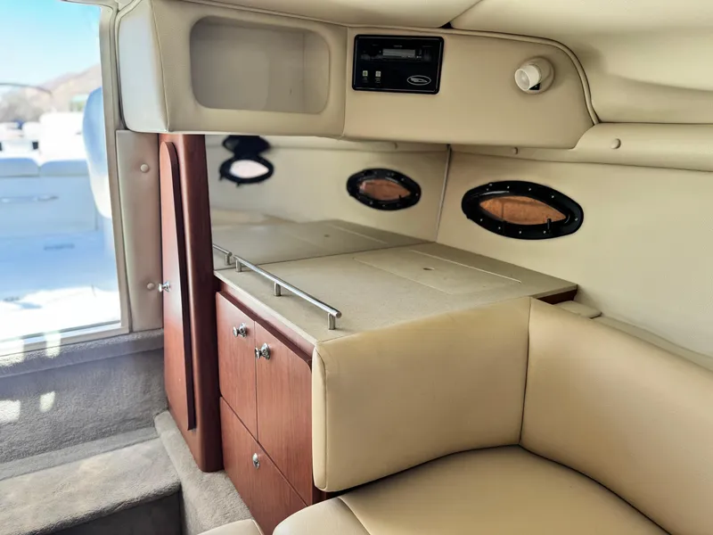 Slide: The Image of 2004 Chaparral 265 SSi boat interior with beige seating and wooden cabinetry. - 21