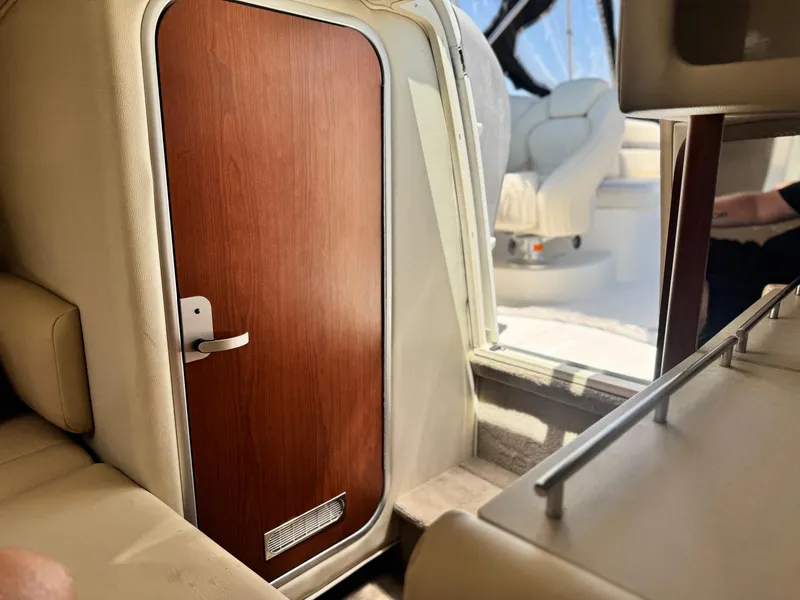 Slide: The Image of Interior of a 2004 Chaparral 265 SSi boat, featuring a wooden cabin door. - 22