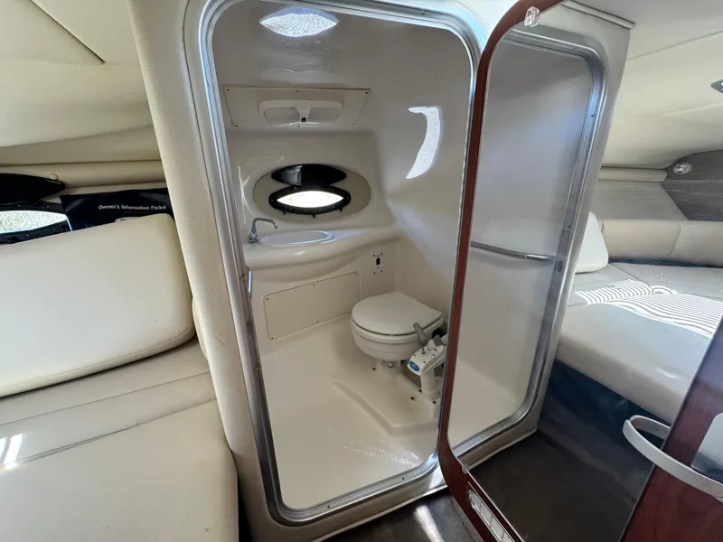 Slide: The Image of 2004 Chaparral 265 SSi boat interior with compact bathroom and cozy cabin space. - 23