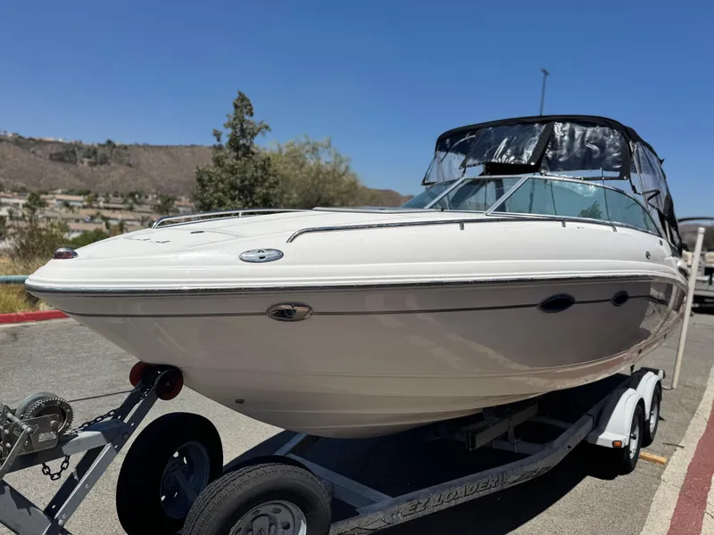 Slide: The Image of 2004 Chaparral 265 SSi boat on trailer, parked outdoors under clear blue sky. - 3
