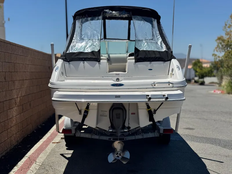 Slide: The Image of 2004 Chaparral 265 SSi boat, rear view with covered cockpit, parked outdoors. - 4