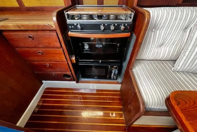 Slide: The Image of 1980 CAL 39 MK II Sloop interior with stove, microwave, and striped seating. - 18