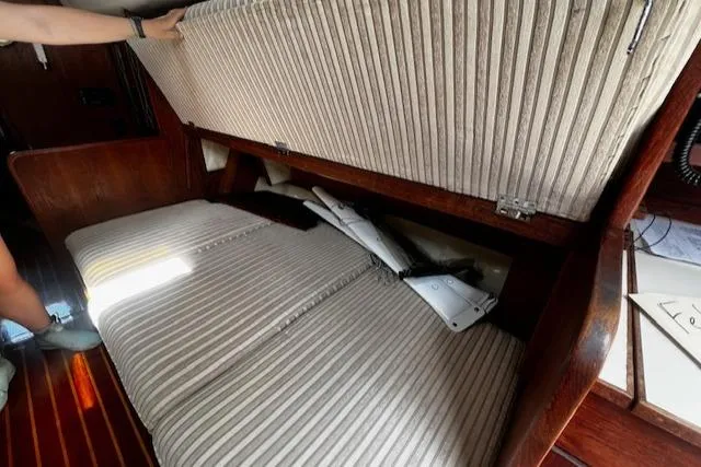 Slide: The Image of Interior of 1980 CAL 39 MK II Sloop showing under-seat storage with striped upholstery. - 19