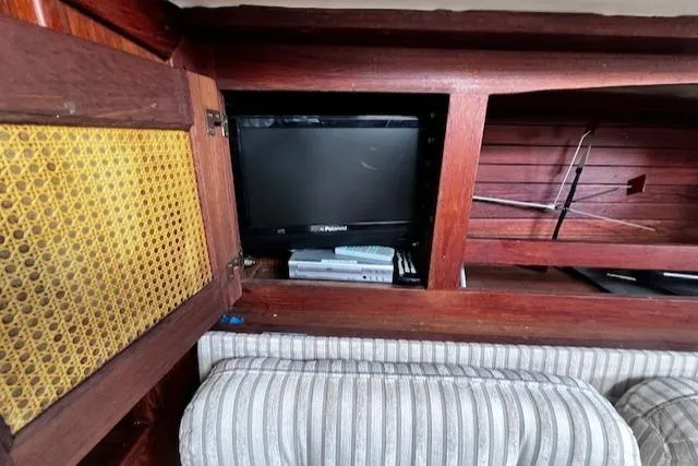 Slide: The Image of 1980 CAL 39 MK II Sloop interior with TV and striped upholstery. - 25