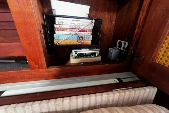 Slide: The Image of Books and electronics in a wooden cabinet on a 1980 CAL 39 MK II Sloop. - 27
