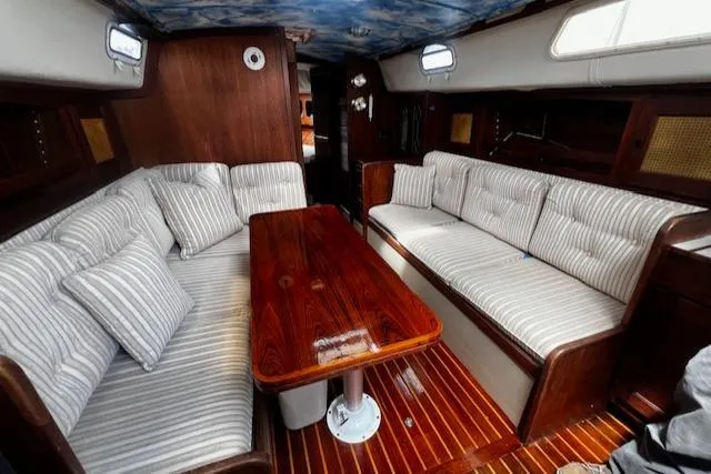 Slide: The Image of Interior of 1980 CAL 39 MK II Sloop with striped seating and polished wooden table. - 3