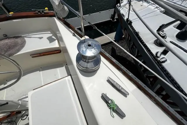 Slide: The Image of Cockpit of 1980 CAL 39 MK II Sloop with winch and cleats, docked beside another boat. - 39