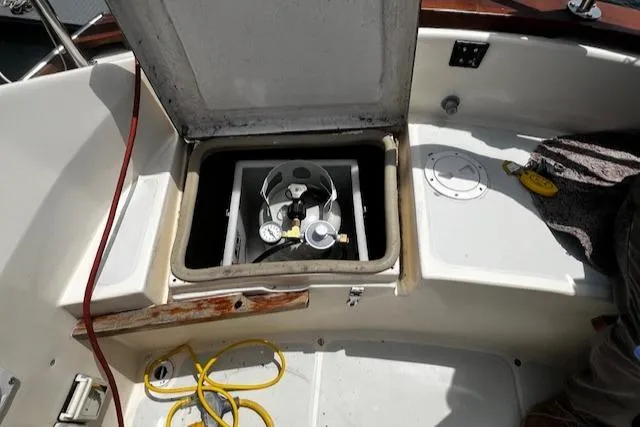 Slide: The Image of Open hatch on 1980 CAL 39 MK II Sloop revealing gas cylinder and gauges. - 49