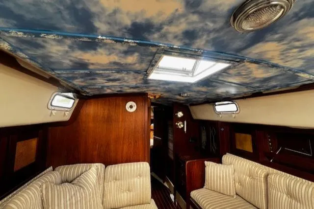 Slide: The Image of Interior of 1980 CAL 39 MK II Sloop with striped seating and sky-patterned ceiling. - 5