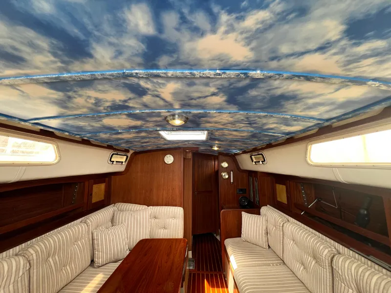 Slide: The Image of Interior of 1980 CAL 39 MK II Sloop with cloud-patterned ceiling and striped seating. - 6