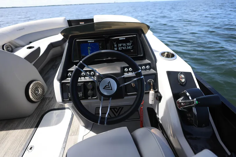 Slide: The Image of 2023 Viaggio DIAMANTE 23S boat dashboard with steering wheel and navigation display on water. - 11