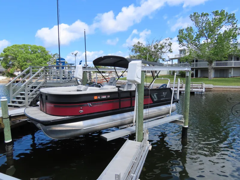 Slide: The Image of 2023 Viaggio DIAMANTE 23S pontoon boat docked on a lift by a lakeside. - 18