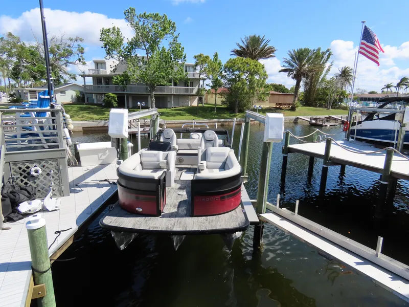 Slide: The Image of 2023 Viaggio DIAMANTE 23S pontoon boat docked at a marina with American flag. - 19