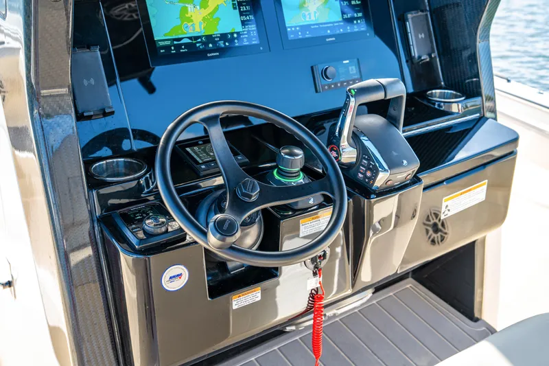 Slide: The Image of 2026 Scout 288 LXF boat dashboard with steering wheel and navigation screens. - 16