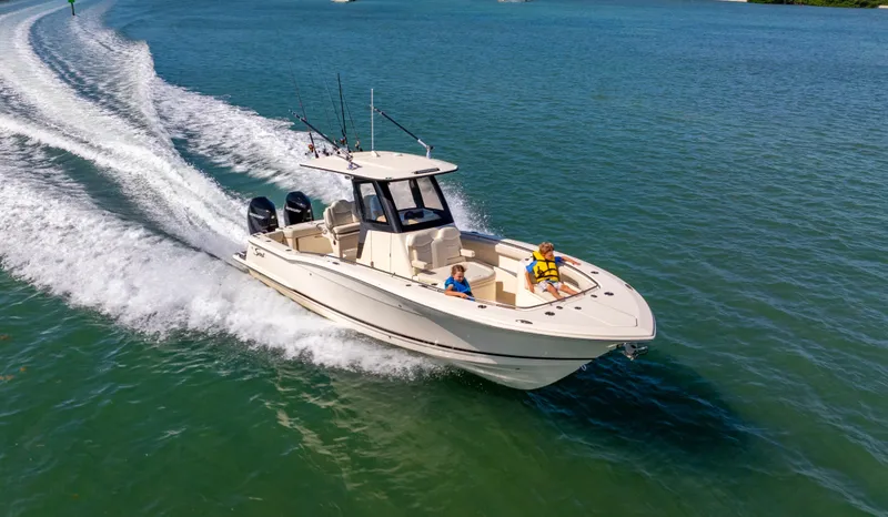 Slide: The Image of 2026 Scout 288 LXF boat cruising on open water with passengers onboard. - 2