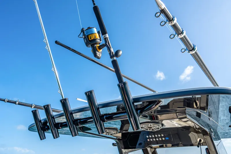 Slide: The Image of Fishing rods on a 2026 Scout 288 LXF boat under a clear blue sky. - 20