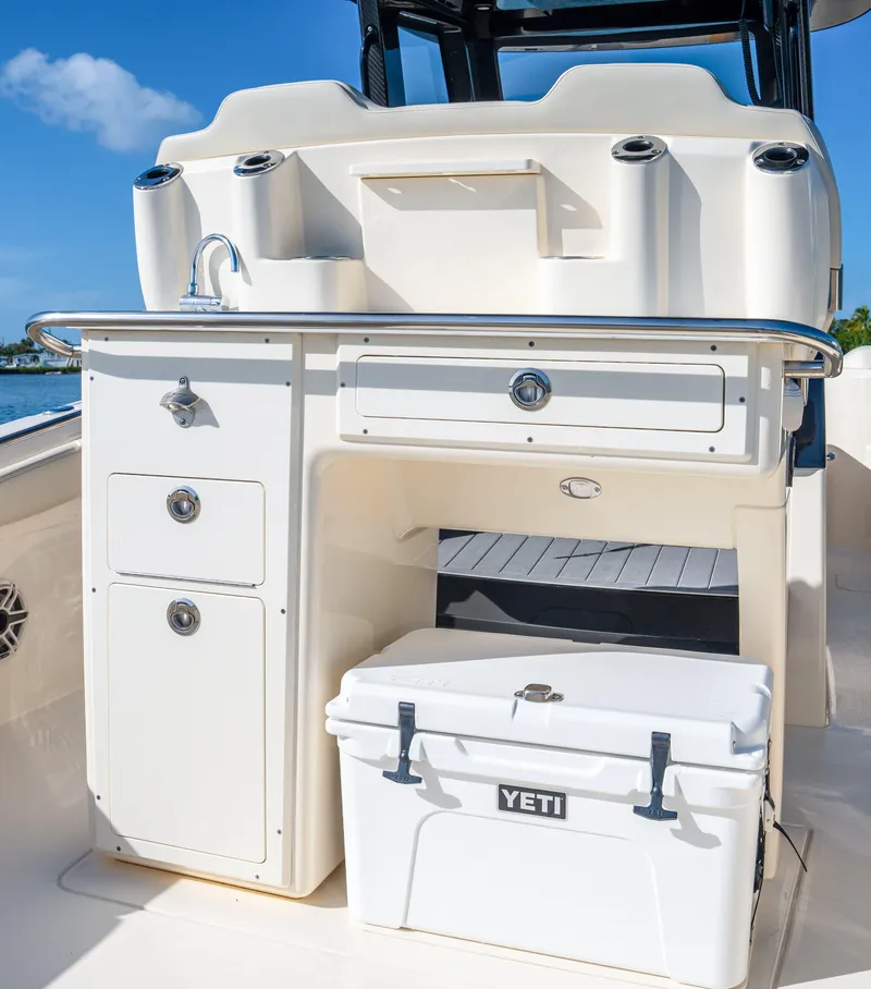 Slide: The Image of 2026 Scout 288 LXF boat interior with sink, storage, and Yeti cooler. - 24