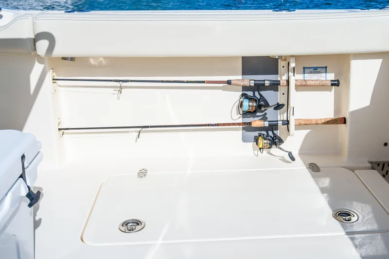 Slide: The Image of 2026 Scout 288 LXF boat with fishing rod holders and storage compartment. - 27