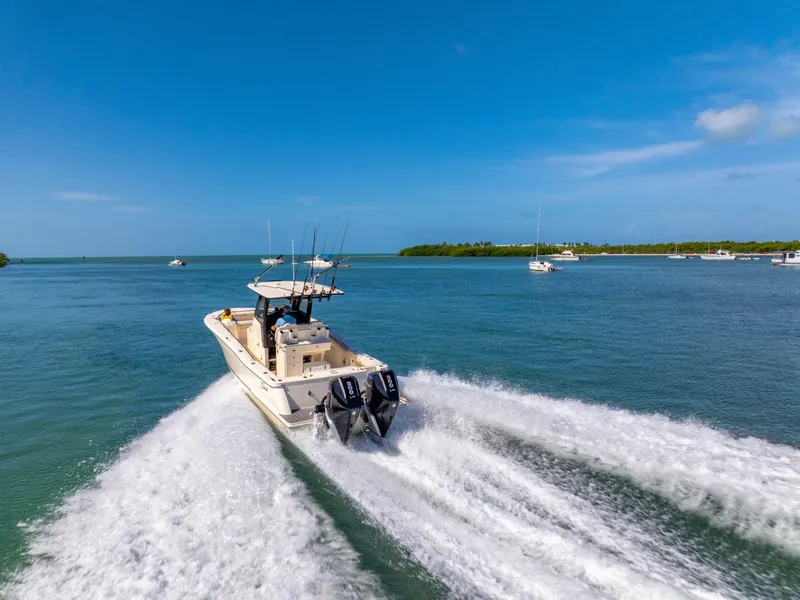 Slide: The Image of 2026 Scout 288 LXF boat cruising on open water under clear blue sky. - 3