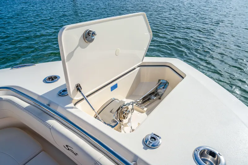 Slide: The Image of 2026 Scout 288 LXF boat anchor compartment open on calm water. - 5