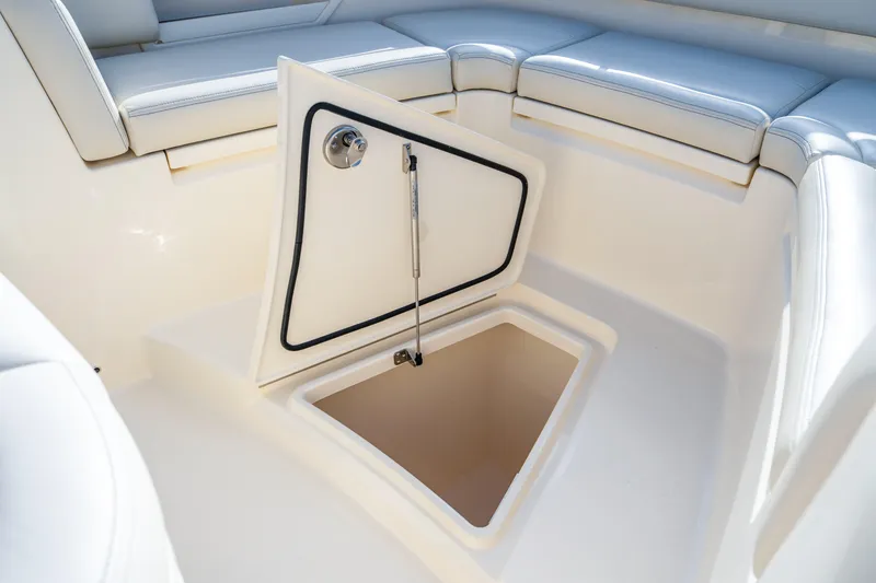 Slide: The Image of 2026 Scout 288 LXF boat with open storage compartment and cushioned seating. - 6