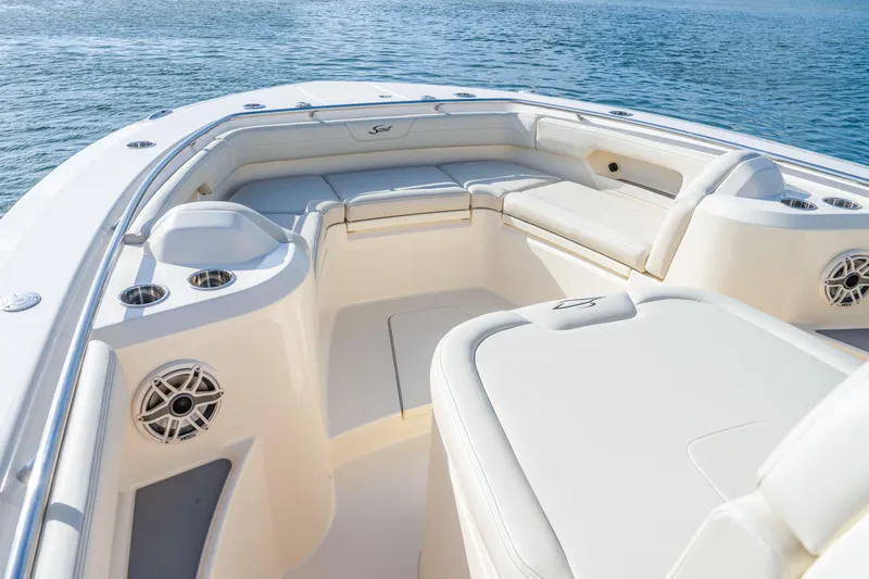 Slide: The Image of 2026 Scout 288 LXF boat interior with luxurious seating and cup holders on calm water. - 8