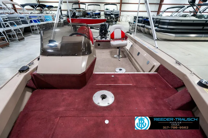 Slide: The Image of 1997 Lund 1700 Pro Angler boat interior with red carpet and seating in showroom. - 15