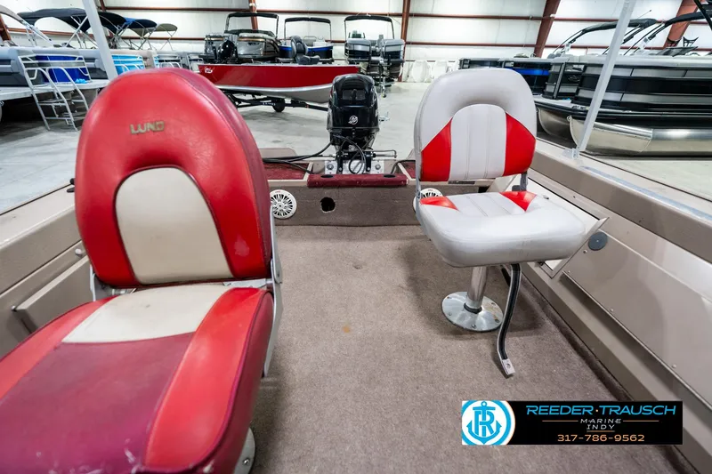 Slide: The Image of 1997 Lund 1700 Pro Angler boat interior with red and white seats in showroom. - 16