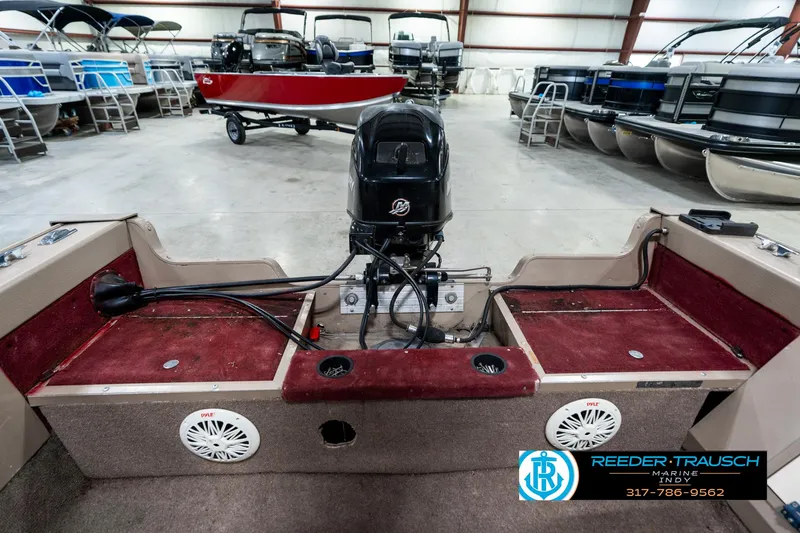 Slide: The Image of 1997 Lund 1700 Pro Angler boat interior with motor, in showroom with other boats. - 17