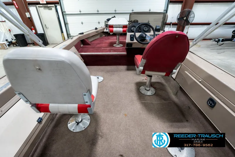 Slide: The Image of Interior of a 1997 Lund 1700 Pro Angler boat with red and white seating. - 18