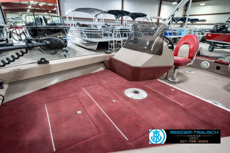 Slide: The Image of 1997 Lund 1700 Pro Angler boat interior with red carpet and seating in showroom. - 22