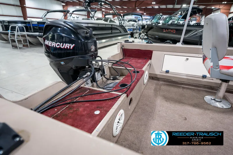 Slide: The Image of 1997 Lund 1700 Pro Angler boat interior with Mercury engine in showroom. - 28