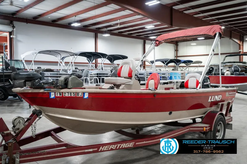 Slide: The Image of 1997 Lund 1700 Pro Angler boat in showroom, red and white, on trailer. - 3