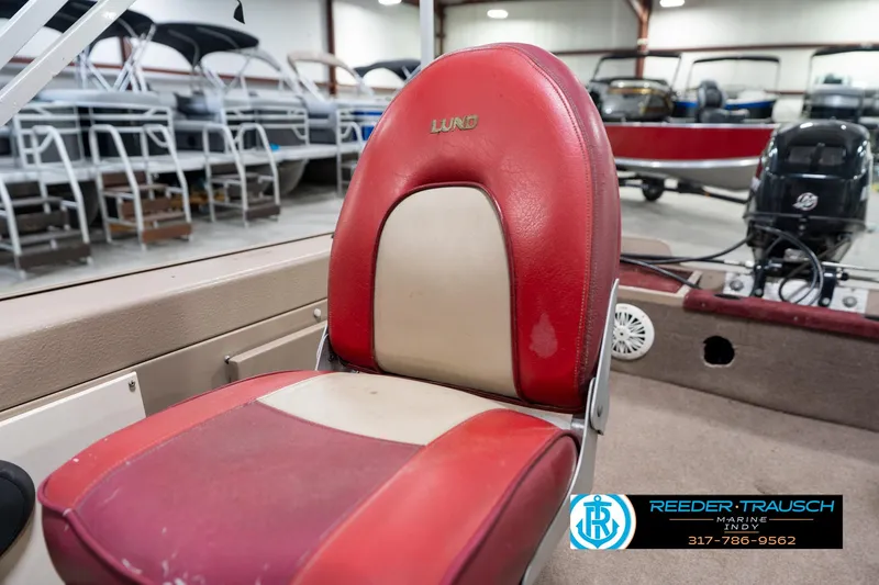 Slide: The Image of 1997 Lund 1700 Pro Angler boat seat in showroom, featuring red and beige upholstery. - 36