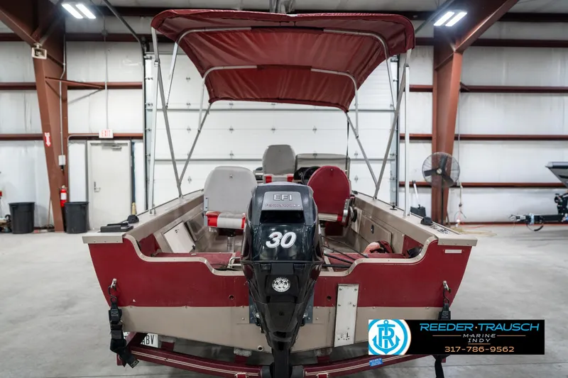 Slide: The Image of 1997 Lund 1700 Pro Angler boat with canopy in a garage setting. - 8