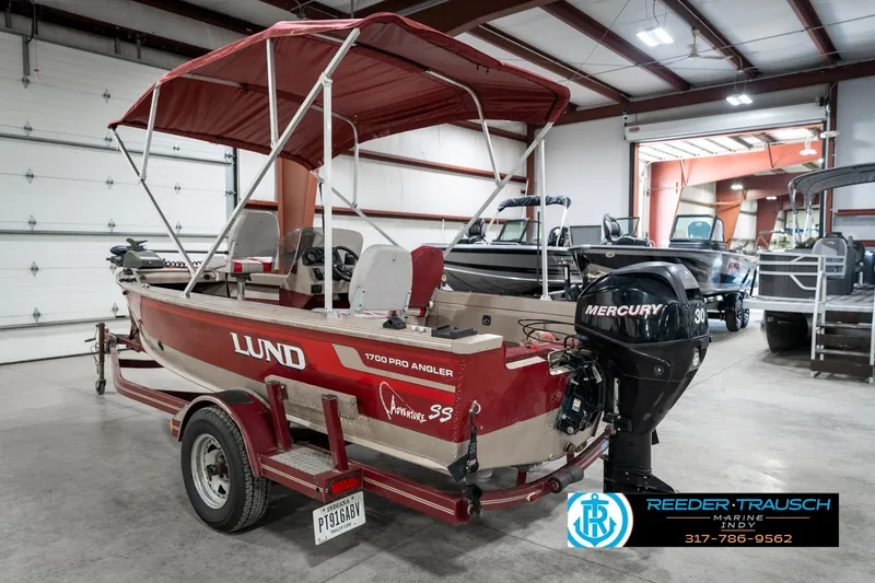 Slide: The Image of 1997 Lund 1700 Pro Angler boat with Mercury engine in a showroom. - 9