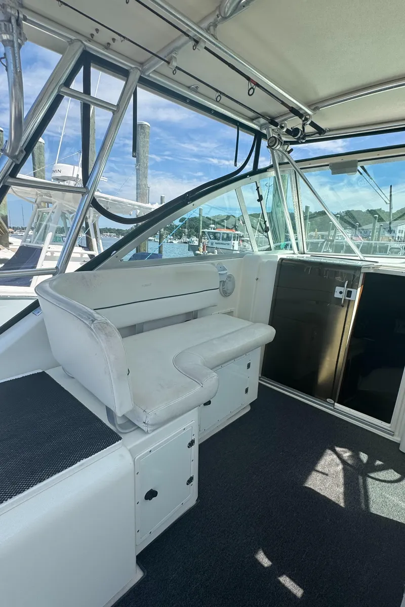 Slide: The Image of 2002 Pursuit 3000 Express boat interior with seating and helm, docked at marina. - 11