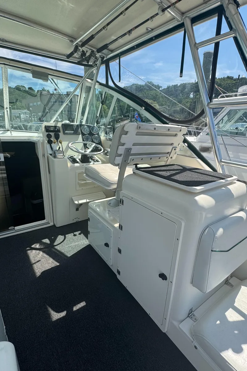 Slide: The Image of 2002 Pursuit 3000 Express boat interior with helm, seating, and control panel. - 12