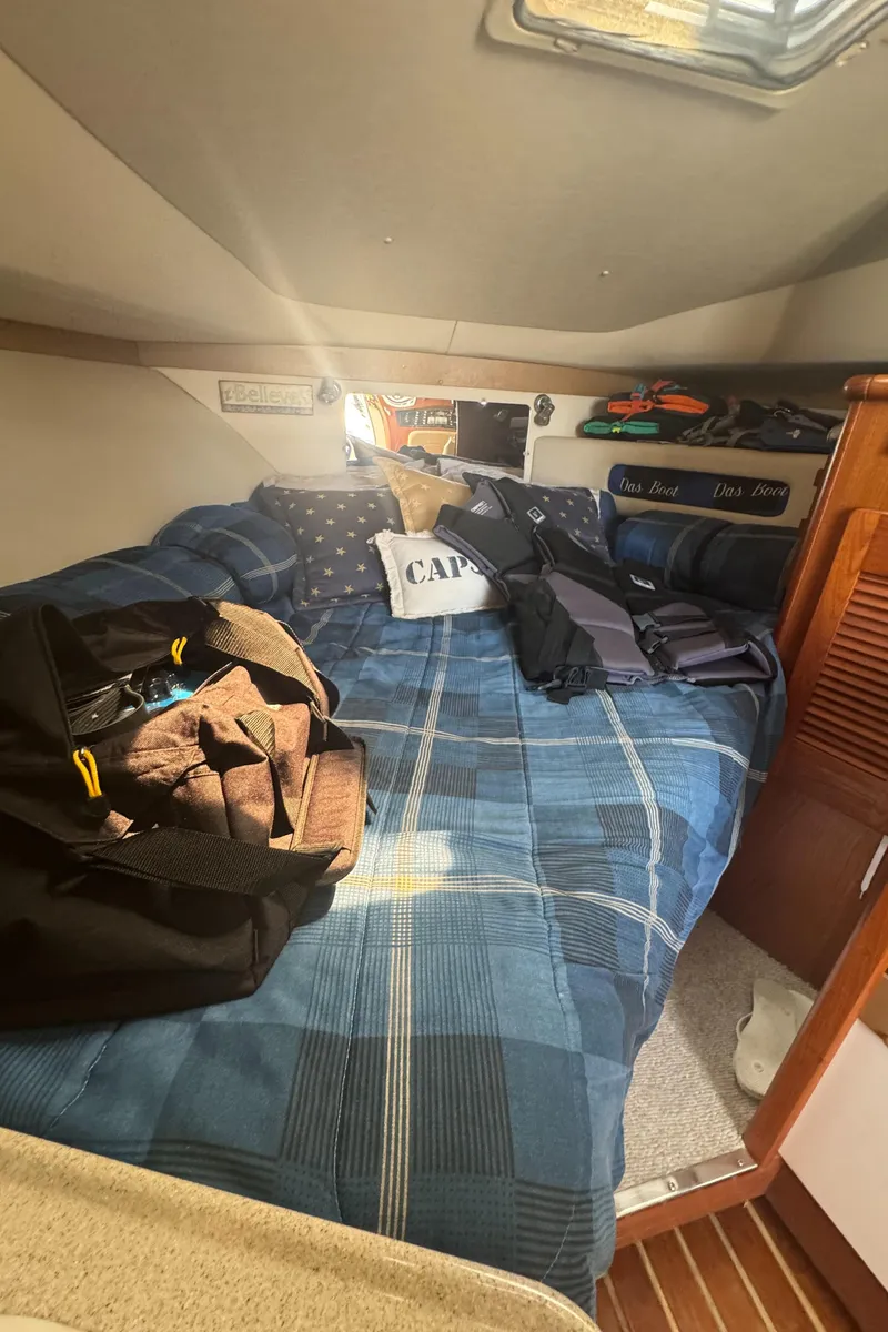 Slide: The Image of Cozy cabin interior of 2002 Pursuit 3000 Express with plaid bedding and nautical decor. - 22