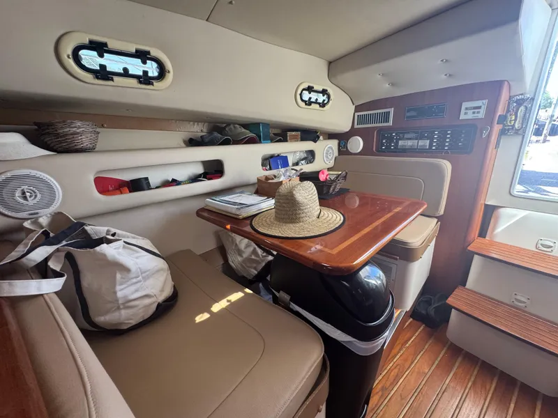 Slide: The Image of Interior of a 2002 Pursuit 3000 Express boat with seating, table, and storage. - 25