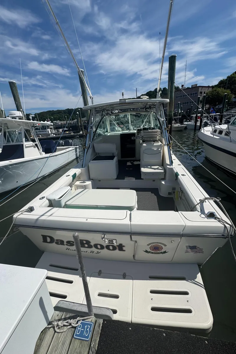 Slide: The Image of 2002 Pursuit 3000 Express boat docked at marina under blue sky. - 3