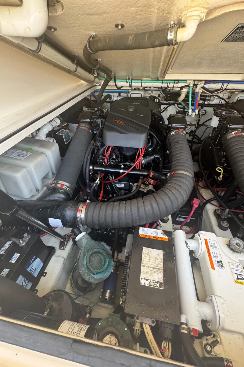 Slide: The Image of Engine compartment of a 2002 Pursuit 3000 Express boat, showcasing V8 engine and components. - 32