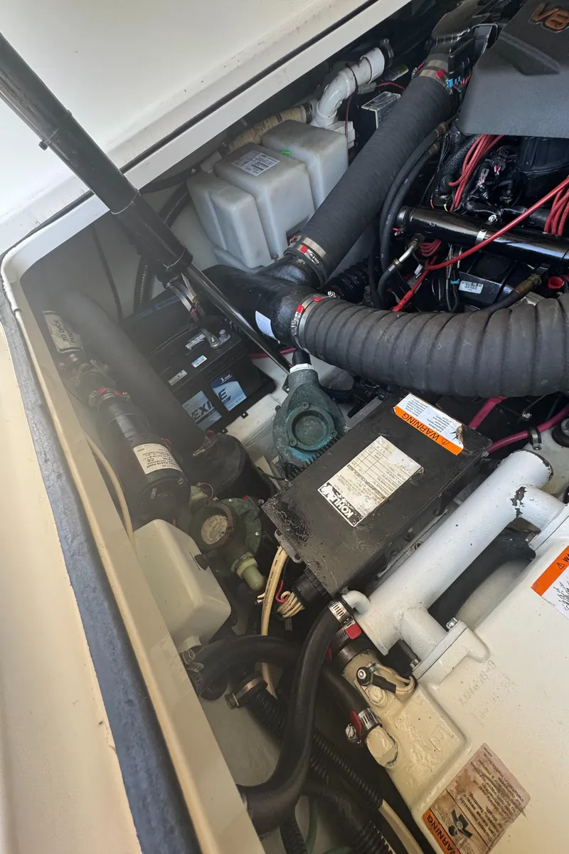 Slide: The Image of Engine compartment of a 2002 Pursuit 3000 Express boat, showcasing mechanical components and wiring. - 35