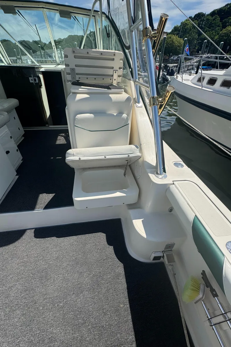 Slide: The Image of 2002 Pursuit 3000 Express boat interior with seating and dock view. - 39
