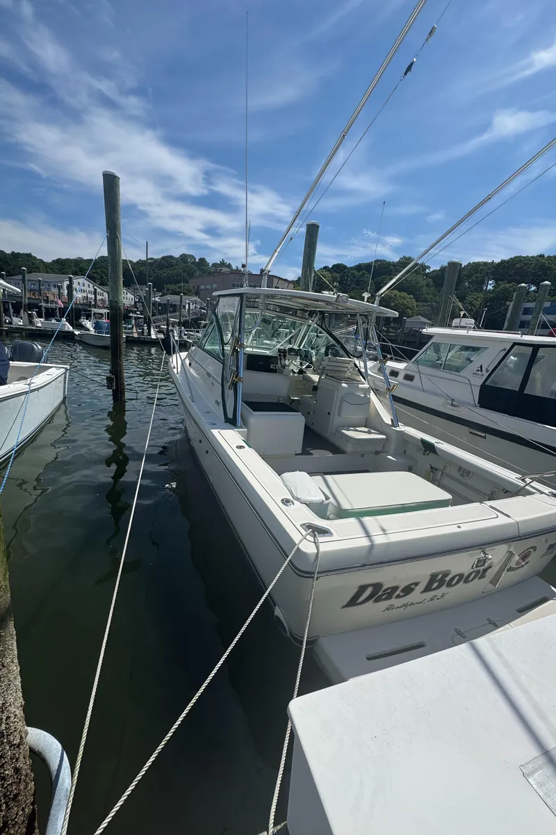 Slide: The Image of 2002 Pursuit 3000 Express boat docked at marina under clear blue sky. - 4