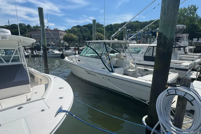 Slide: The Image of 2002 Pursuit 3000 Express boat docked at a marina on a sunny day. - 5